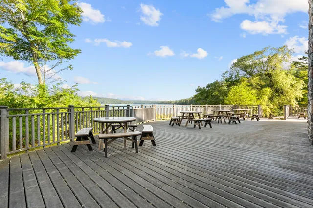 a roof deck with table and chairs a barbeque with wooden floor and fence