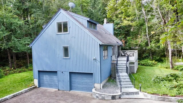 a house view with a garden and large trees