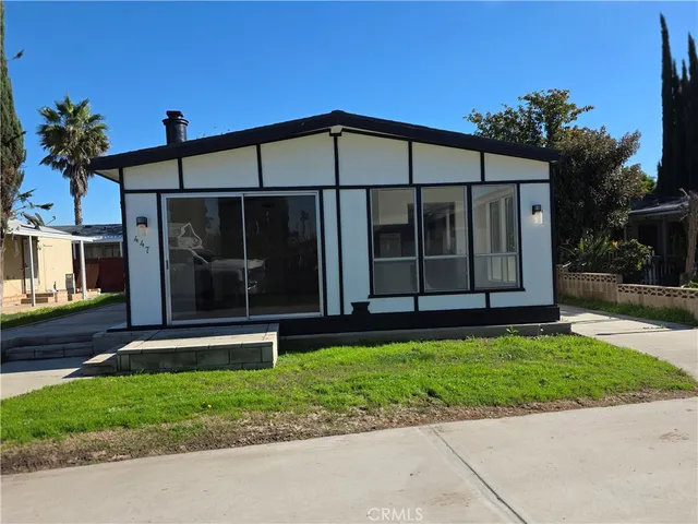 a view of a house with a yard and a garden