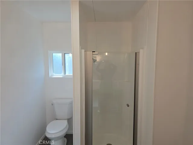 a bathroom with a toilet and a shower