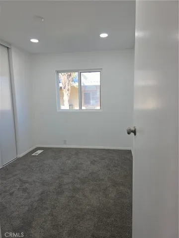 a view of a room with wooden floor chandelier fan and windows