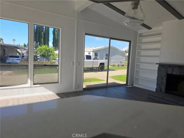 a view of an empty room with a fireplace and a window