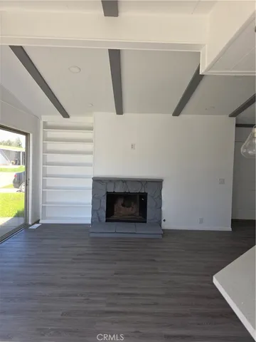 a view of an empty room with a fireplace and a window