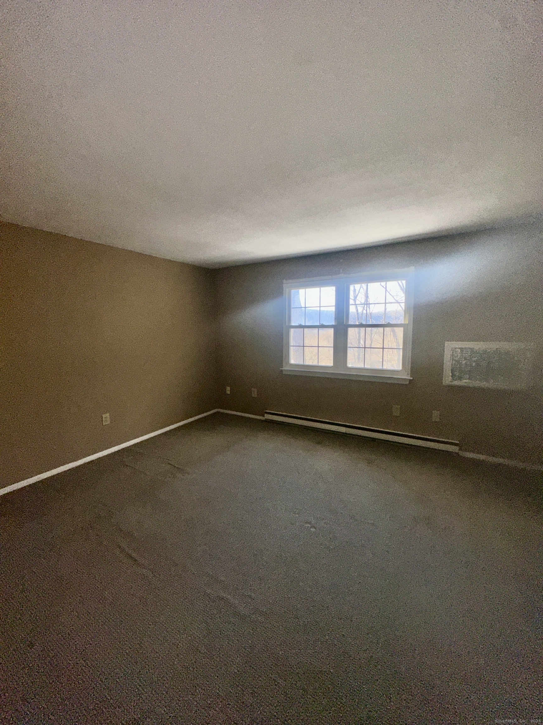 18 Canterbury Arms, Unit 18 New Milford, CT 06776 - Photo 5 of 6 an empty room with a window