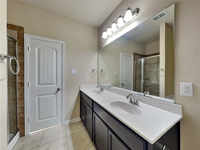 a bathroom with a sink double vanity granite and a mirror