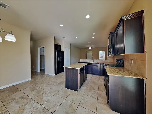 a large kitchen with a large counter top space and stainless steel appliances