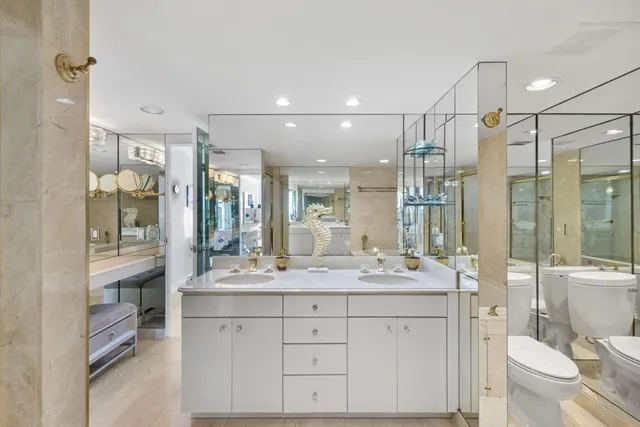 a bathroom with a double vanity sink toilet mirror and bathtub