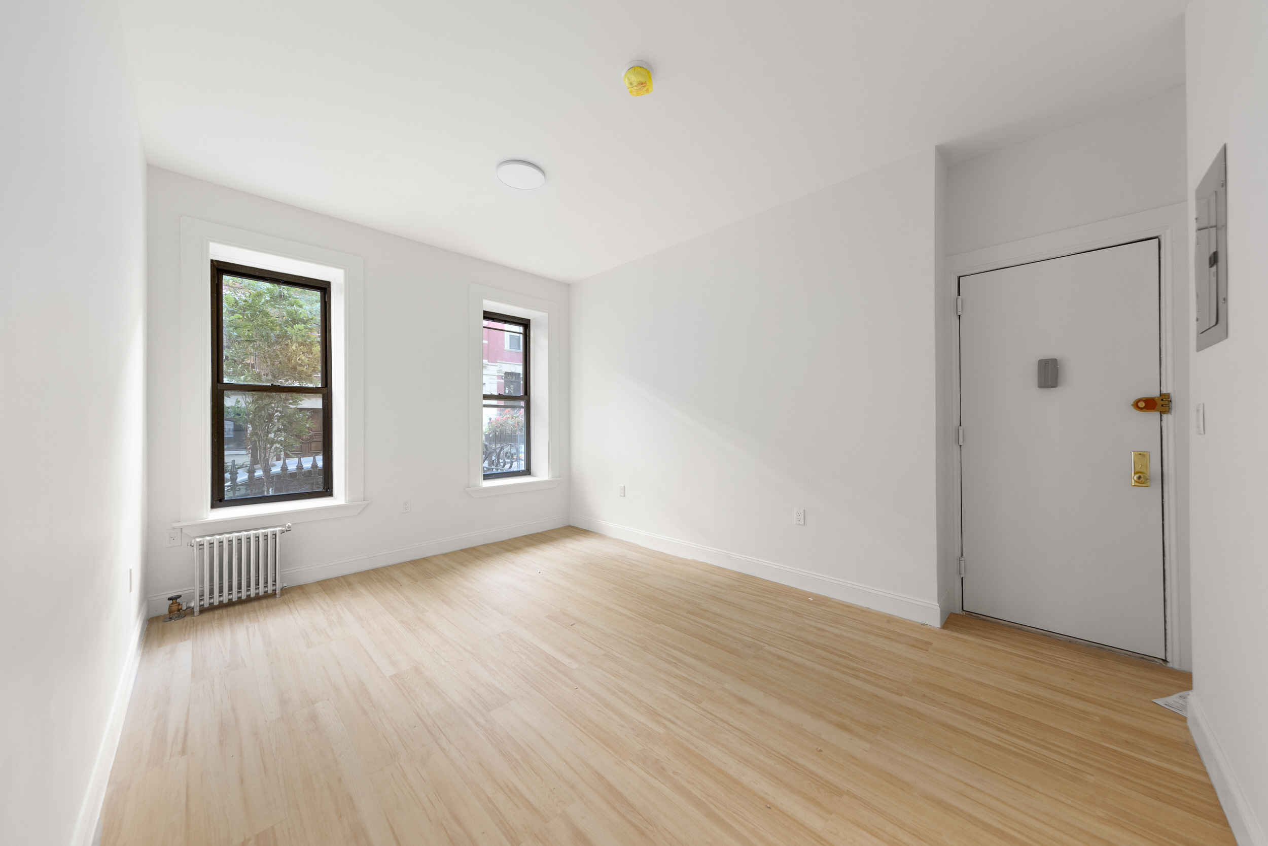 an empty room with wooden floor and windows