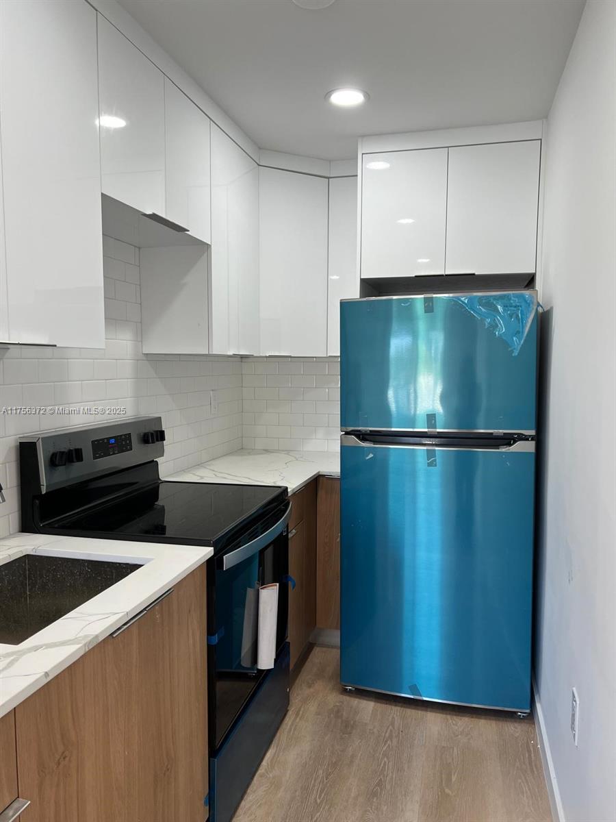 4227 Northwest 5th Street, Unit 8 Miami, FL 33126 - Photo 12 of 12 a kitchen with a refrigerator and a stove top oven