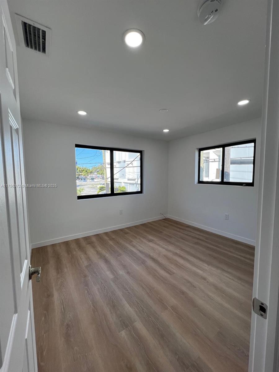 4227 Northwest 5th Street, Unit 8 Miami, FL 33126 - Photo 10 of 12 a view of an empty room with wooden floor and a window