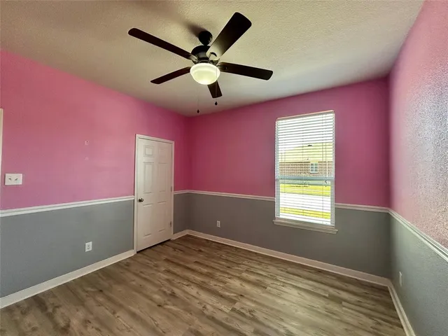 a view of empty room with window and ceiling fan