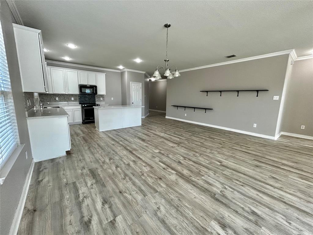 2336 Buelingo Lane Fort Worth, TX 76131 - Photo 6 of 27 a view of a kitchen with kitchen island a sink wooden floor and a refrigerator