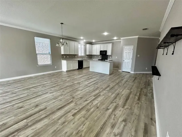 a view of kitchen with microwave refrigerator and cabinets