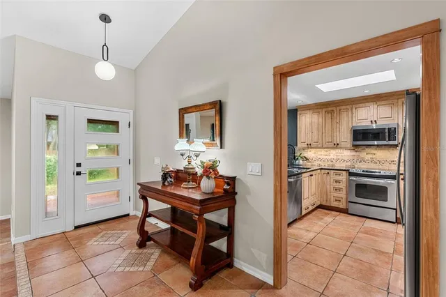 a view of a livingroom with a fireplace a ceiling fan and windows