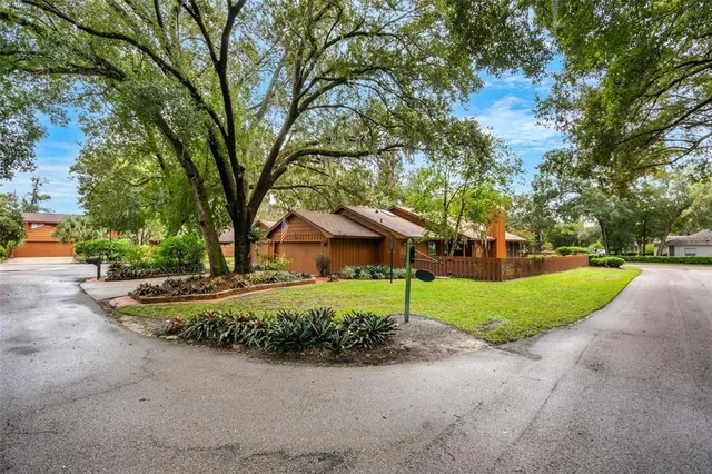 a view of a house with a big yard and large trees