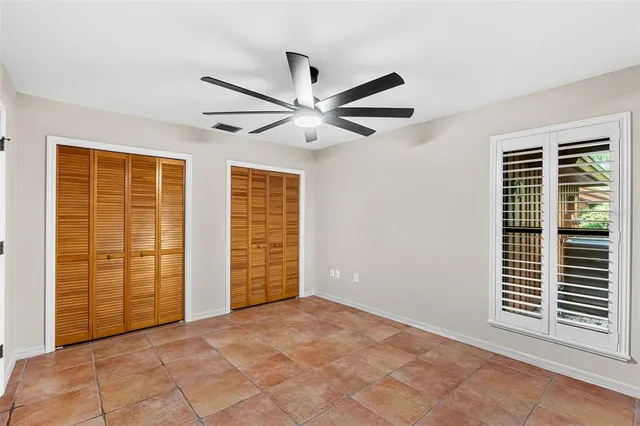 a view of backyard with large tree and wooden fence