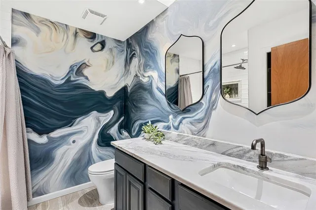 a view of a house with a small yard plants and large tree