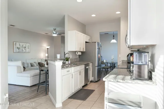 a large white kitchen with stainless steel appliances