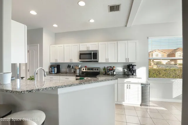 a kitchen with stainless steel appliances granite countertop a sink a stove a microwave a counter top and cabinets