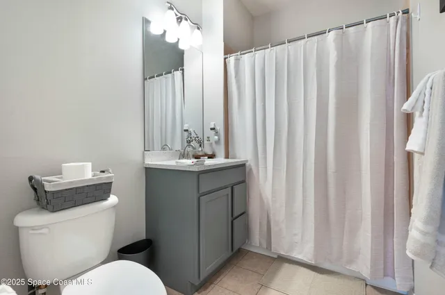 a bathroom with a sink a toilet and shower curtain