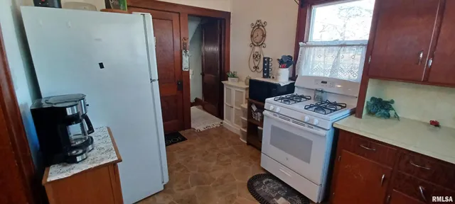 a kitchen with a refrigerator stove and a window