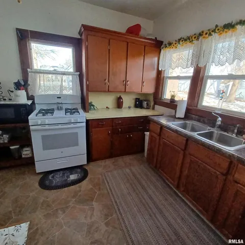 a kitchen with stainless steel appliances granite countertop a sink stove and cabinets
