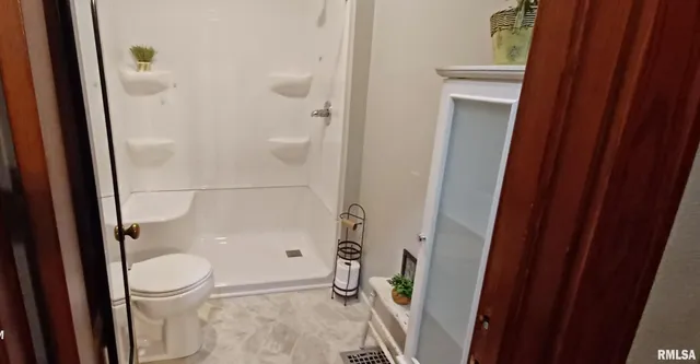 a bathroom with a toilet and a shower