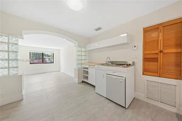 a kitchen with white cabinets and white appliances