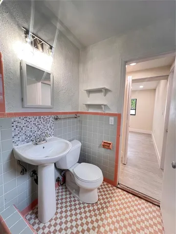 a bathroom with a sink a toilet a mirror and shower