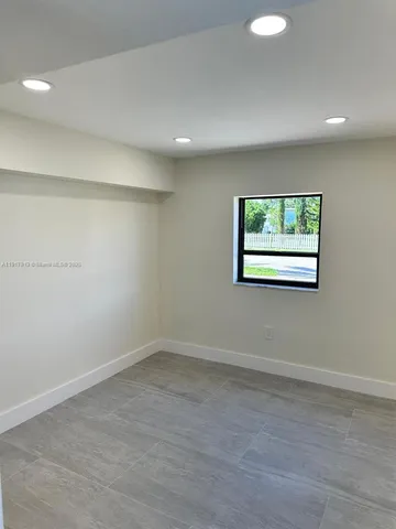 a large kitchen with stainless steel appliances a large counter top a stove and a window