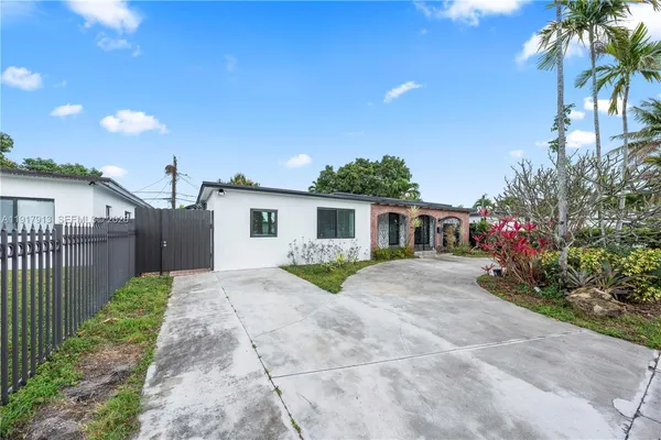a view of a house with a yard and potted plants