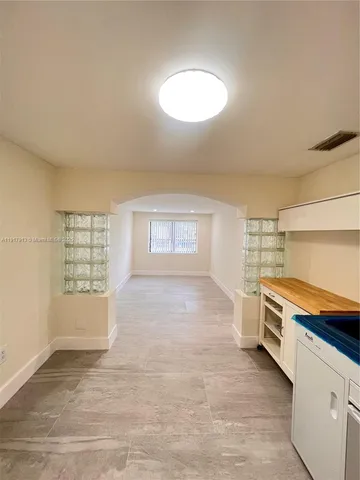 an empty room with windows and cabinet