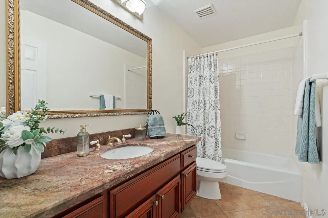 10235 Rue Chamberry San Diego, CA 92131 - Photo 30 of 72 a bathroom with a granite countertop sink a toilet and shower