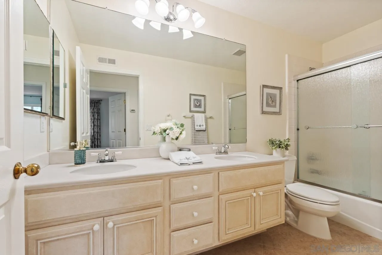 10235 Rue Chamberry San Diego, CA 92131 - Photo 42 of 72 a bathroom with a double vanity sink toilet mirror and shower