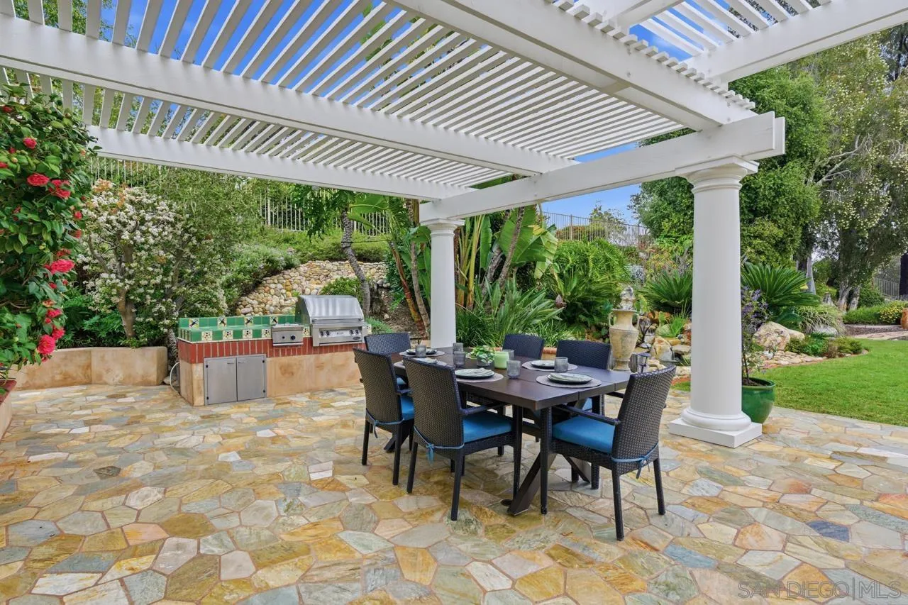 10235 Rue Chamberry San Diego, CA 92131 - Photo 48 of 72 a view of a patio with a table chairs and a backyard
