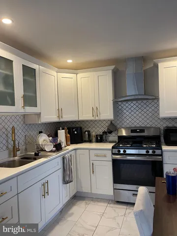 a kitchen with white cabinets and appliances