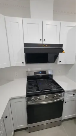 a stove top oven sitting inside of a kitchen