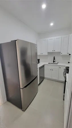 a kitchen with stainless steel appliances a refrigerator sink and cabinets