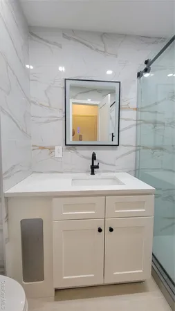 a bathroom with a sink a toilet and mirror