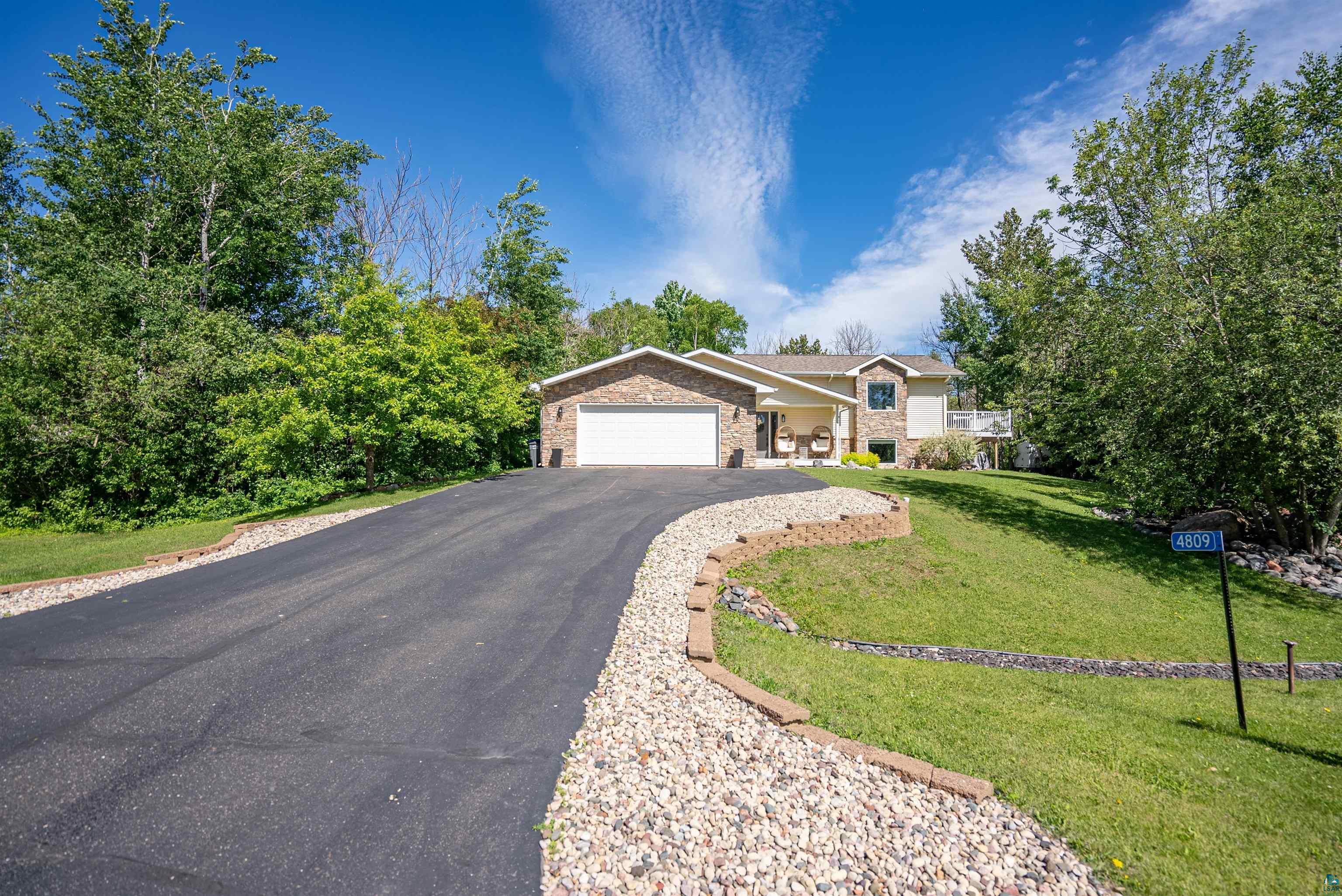 4809 Oak Ridge Drive Hermantown, MN 55811 - Photo 63 of 67 Asphalt driveway leading to a residence featuring a brick facade and an integrated two-car garage