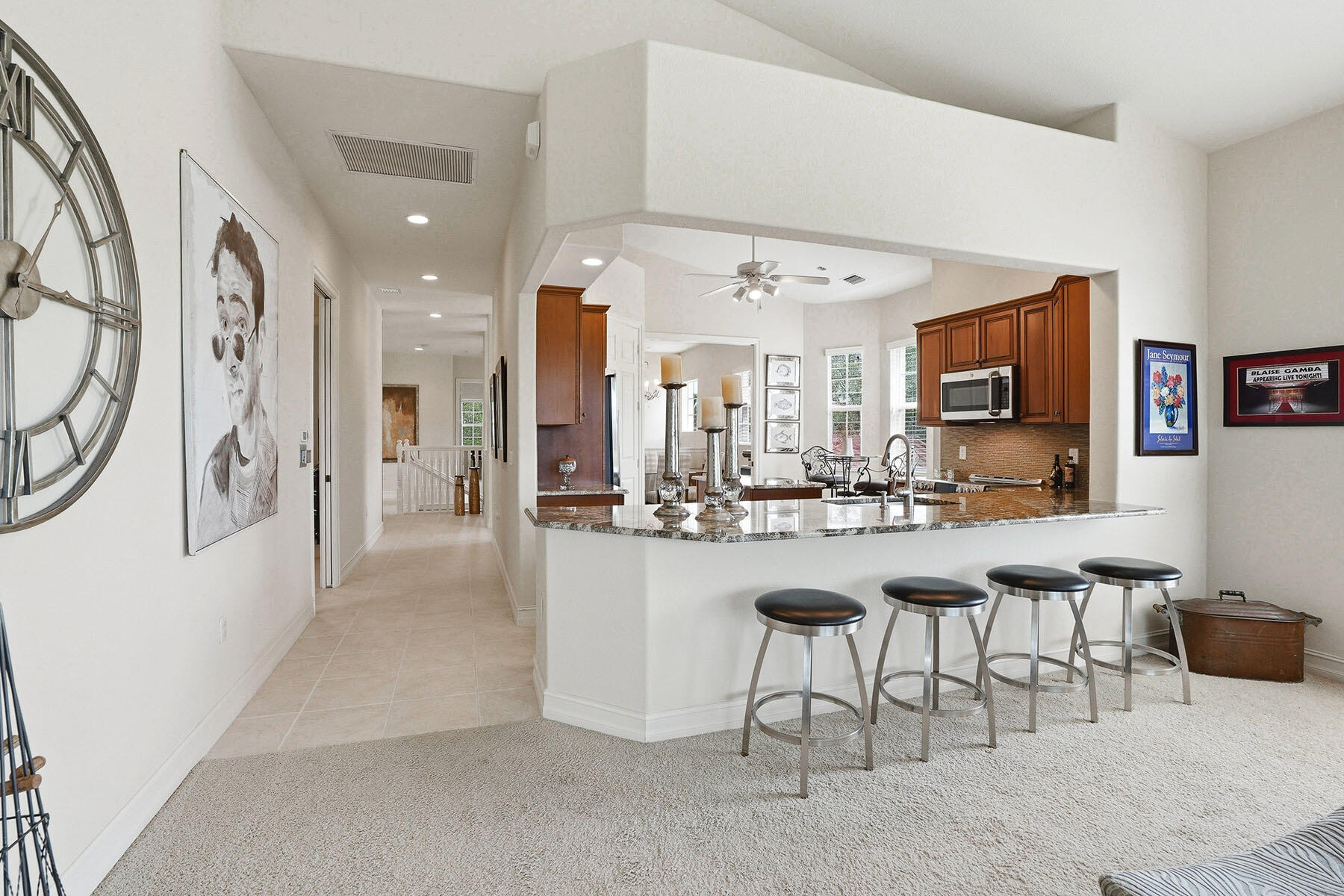8605 Champions Point, Unit 103 Naples, FL 34113 - Photo 14 of 44 a kitchen with stainless steel appliances kitchen island granite countertop a table and chairs in it