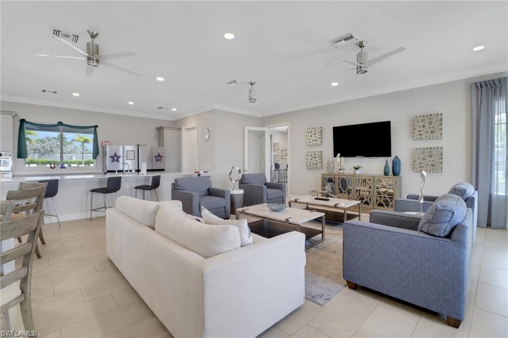 847 Enbrook Loop Naples, FL 34114 - Photo 14 of 17 a living room with furniture kitchen area and a flat screen tv