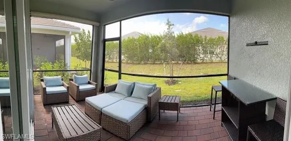 a view of two chairs and a table in the balcony
