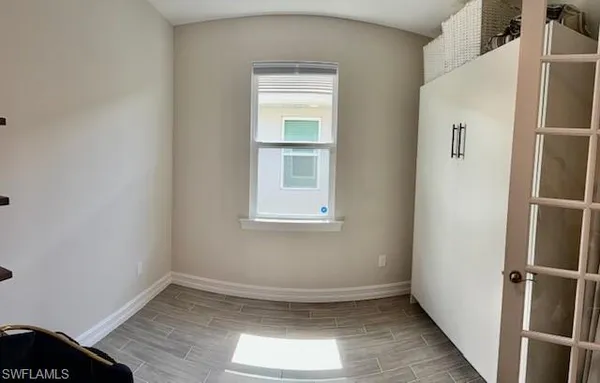 a view of empty room with wooden floor and fan