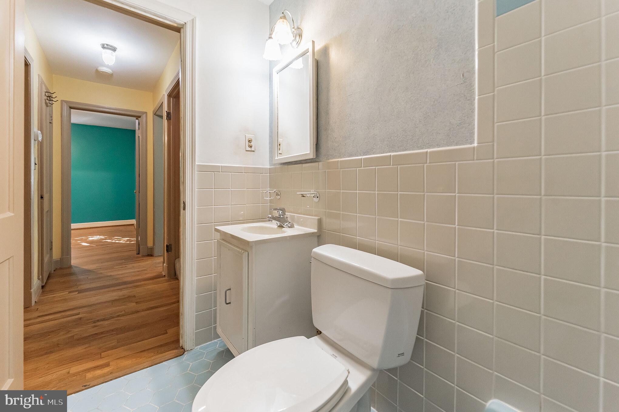 403 Belton Road Silver Spring, MD 20901 - Photo 13 of 22 a bathroom with a toilet a sink a mirror and vanity