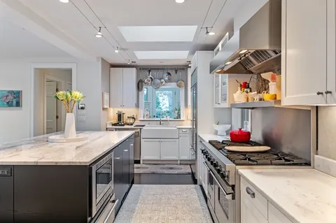 a kitchen with stainless steel appliances granite countertop a kitchen island a stove and a refrigerator