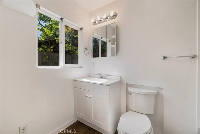 a view of a livingroom with wooden floor and a ceiling fan
