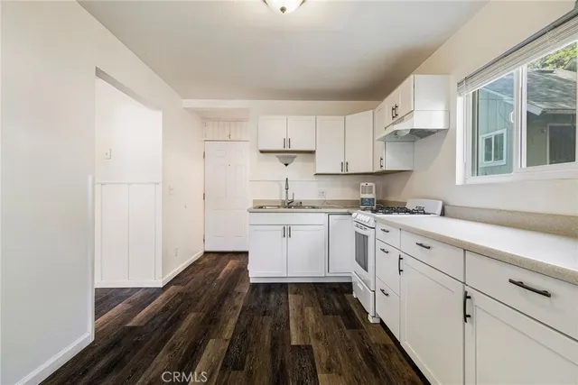 a view of a backyard with plants and wooden fence