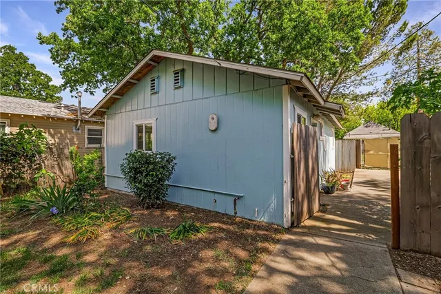 a view of a house with a small yard and wooden floor and fence