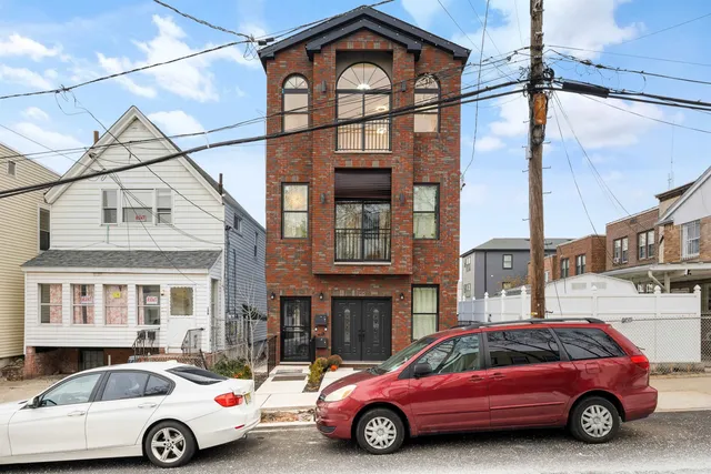 a car parked in front of a big house
